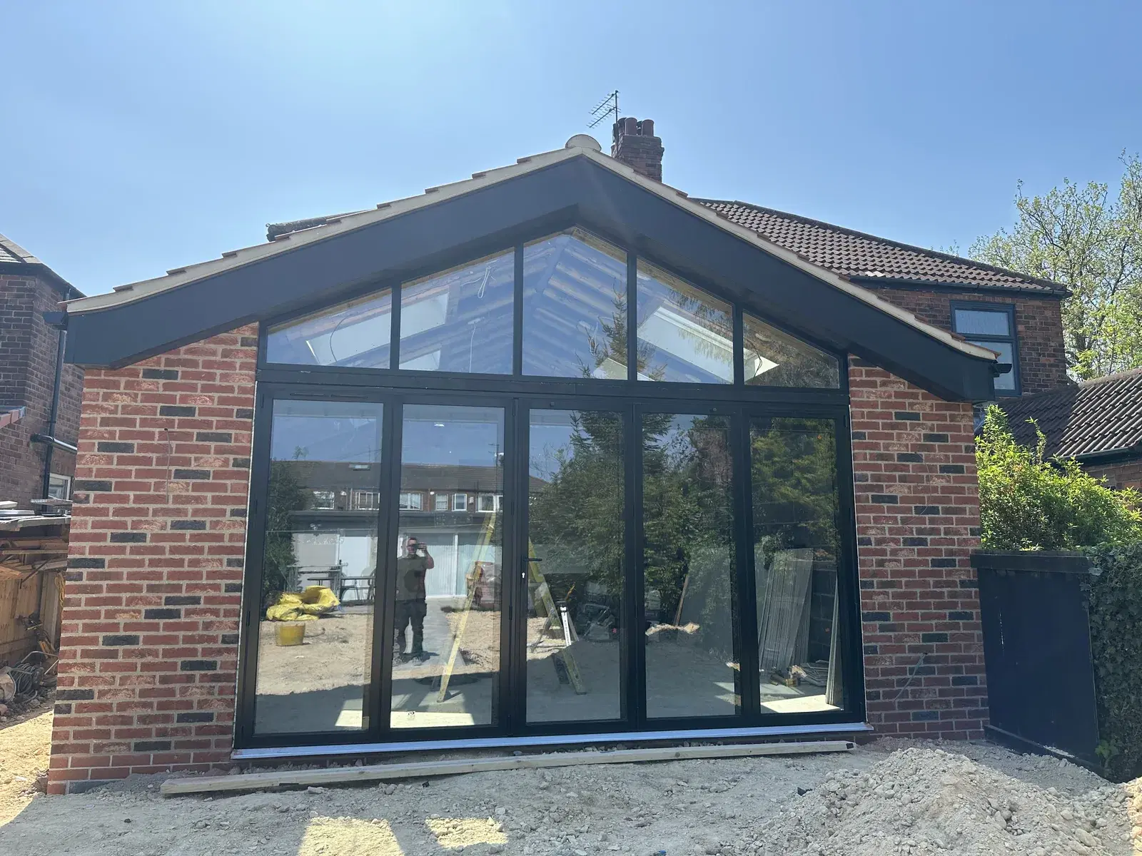 The same brick extension with its bi-folding doors closed, reflecting the garden.
