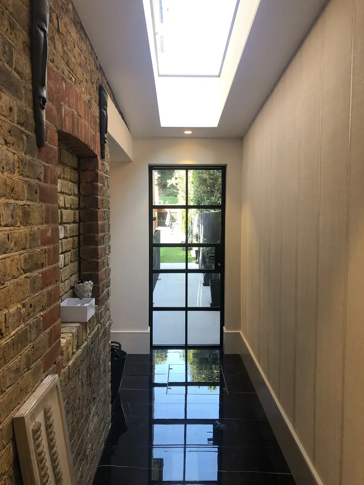 A slim-framed heritage window with astragal bars in a traditional facade.